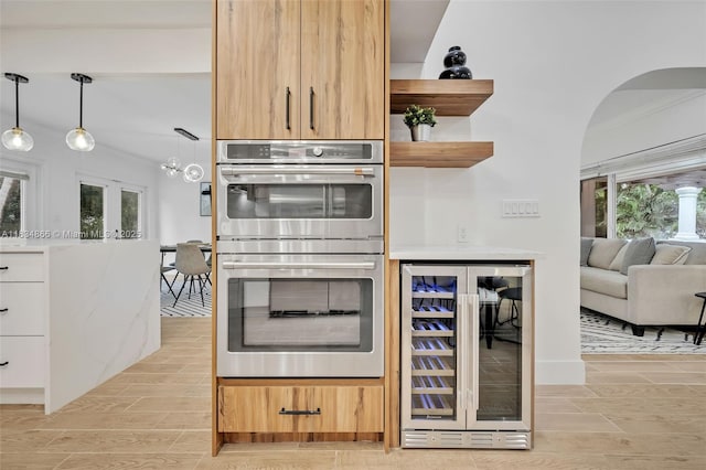 5701 SW 33rd St, Miami, FL 33155 - kitchen with wine cooler, stainless steel double oven, open shelves, arched walkways, and ornamental molding