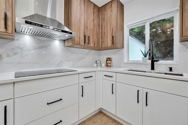 5701 SW 33rd St, Miami, FL 33155 - kitchen featuring wall chimney exhaust hood, decorative backsplash, light countertops, black electric stovetop, and white cabinetry