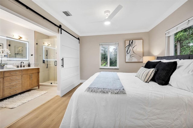 5701 SW 33rd St, Miami, FL 33155 - bedroom featuring light wood-type flooring, a barn door, multiple windows, connected bathroom, and crown molding