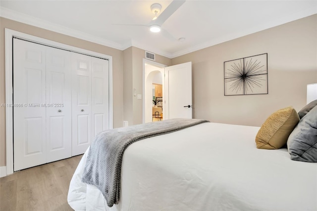 5701 SW 33rd St, Miami, FL 33155 - bedroom featuring light wood-style flooring, ornamental molding, a ceiling fan, a closet, and arched walkways