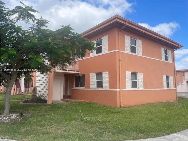 3401 SW 11th St Unit 1B, Miami, FL 33135 - view of side of home with stucco siding, a yard, stone siding, and a balcony