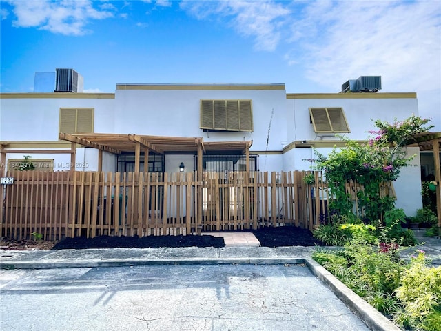 1725 SW 131st Place Cir S, Miami, FL 33175 - rear view of house featuring stucco siding, a fenced front yard, and uncovered parking