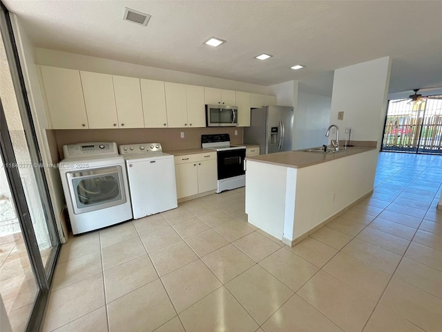 1725 SW 131st Place Cir S, Miami, FL 33175 - kitchen with appliances with stainless steel finishes, independent washer and dryer, light tile patterned floors, a peninsula, and light countertops
