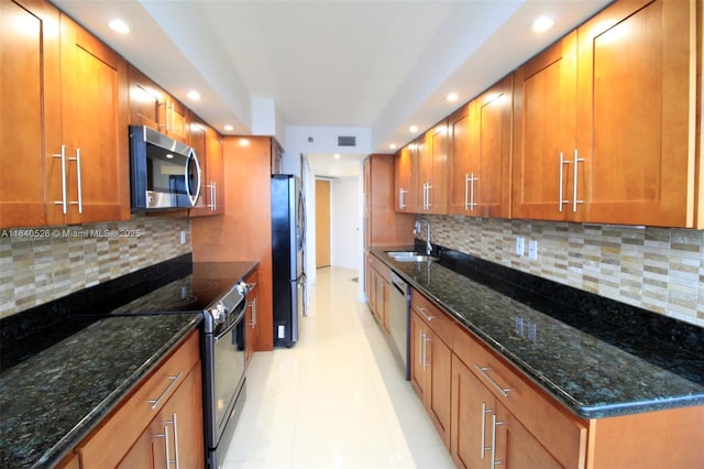 20185 E Country Club Dr Unit 1105, Aventura, FL 33180 - kitchen featuring appliances with stainless steel finishes, brown cabinets, recessed lighting, backsplash, and dark stone countertops