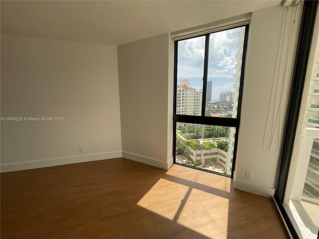 20185 E Country Club Dr Unit 1105, Aventura, FL 33180 - spare room with healthy amount of natural light, wood finished floors, a wall of windows, and a city view