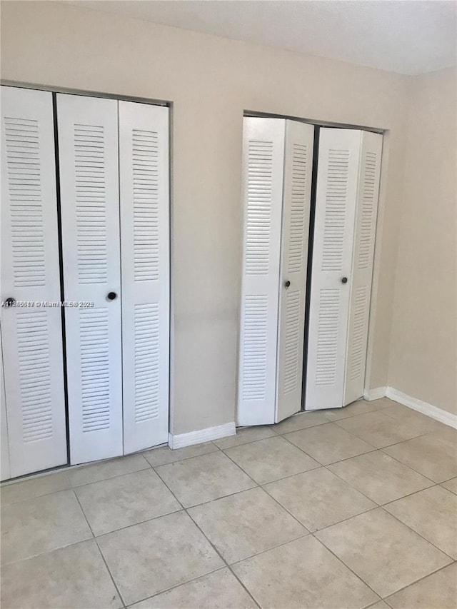 3201 W Flagler St Unit 102, Miami, FL 33135 - unfurnished bedroom featuring light tile patterned flooring and two closets