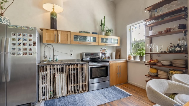 1521 Lenox Ave Unit 307, Miami Beach, FL 33139 - kitchen featuring appliances with stainless steel finishes, light wood-type flooring, glass insert cabinets, and open shelves