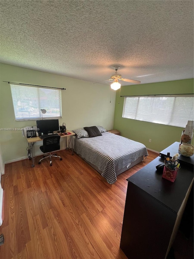 10415 E Clairmont Cir Unit 212, Tamarac, FL 33321 - bedroom featuring wood finished floors, a textured ceiling, an office area, and a ceiling fan
