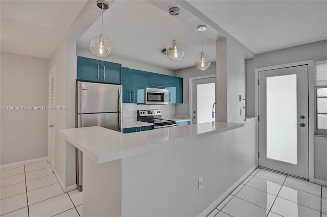 1100 11th St Unit 204, Miami Beach, FL 33139 - kitchen featuring appliances with stainless steel finishes, blue cabinetry, light tile patterned floors, a peninsula, and pendant lighting