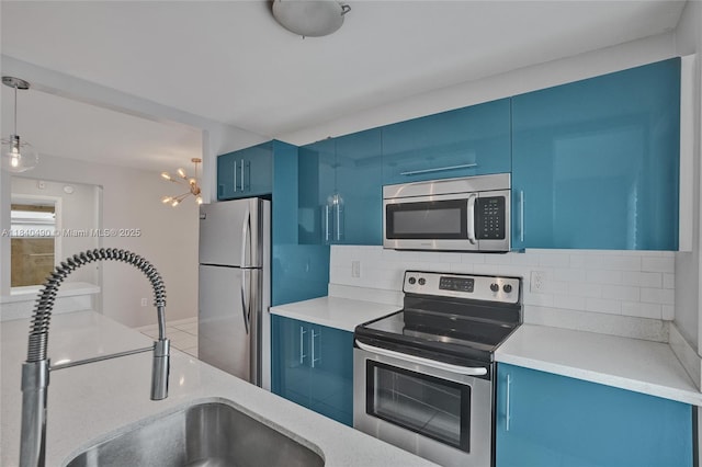 1100 11th St Unit 204, Miami Beach, FL 33139 - kitchen featuring stainless steel appliances, blue cabinets, and backsplash