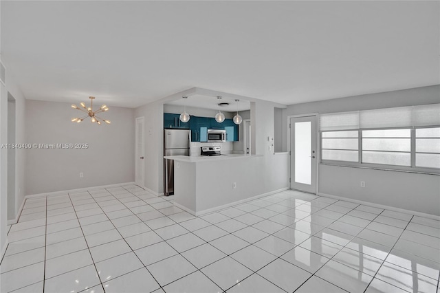 1100 11th St Unit 204, Miami Beach, FL 33139 - kitchen featuring stainless steel appliances, blue cabinetry, a chandelier, light countertops, and a peninsula