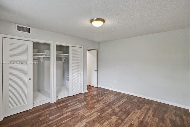 1100 11th St Unit 204, Miami Beach, FL 33139 - unfurnished bedroom with wood finished floors, two closets, and a textured ceiling