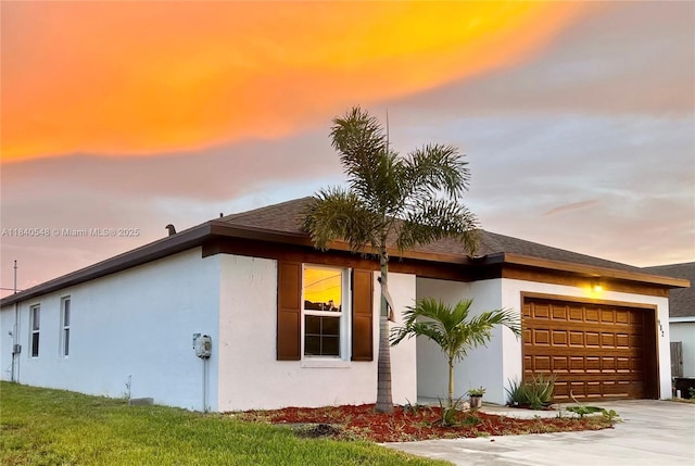 982 SW Alcantarra Blvd, Port St Lucie, FL 34953 - property exterior at dusk with a garage, driveway, and stucco siding