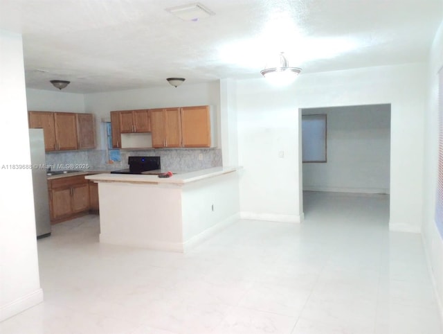 14760 Tyler St, Miami, FL 33176 - kitchen featuring tasteful backsplash, stove, a peninsula, and freestanding refrigerator