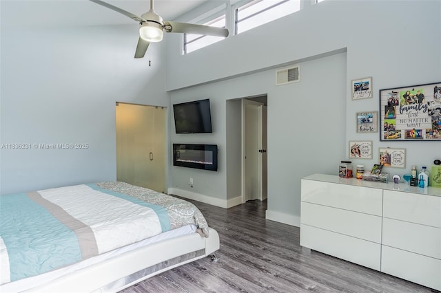 1000 NE 204th Ln Unit D, Miami, FL 33179 - bedroom with a high ceiling, wood finished floors, ceiling fan, and a glass covered fireplace