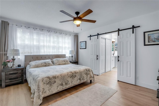 1204 Bayview Cir, Weston, FL 33326 - bedroom featuring a barn door, light wood-type flooring, and ceiling fan