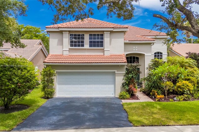 1204 Bayview Cir, Weston, FL 33326 - mediterranean / spanish house featuring driveway, stucco siding, an attached garage, and a front yard