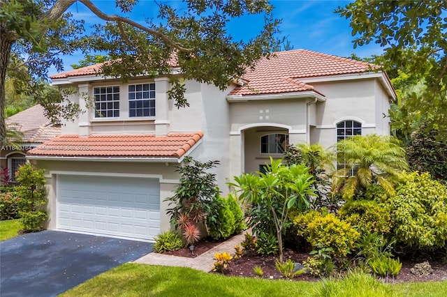 1204 Bayview Cir, Weston, FL 33326 - mediterranean / spanish-style home featuring stucco siding, asphalt driveway, a tiled roof, and a garage