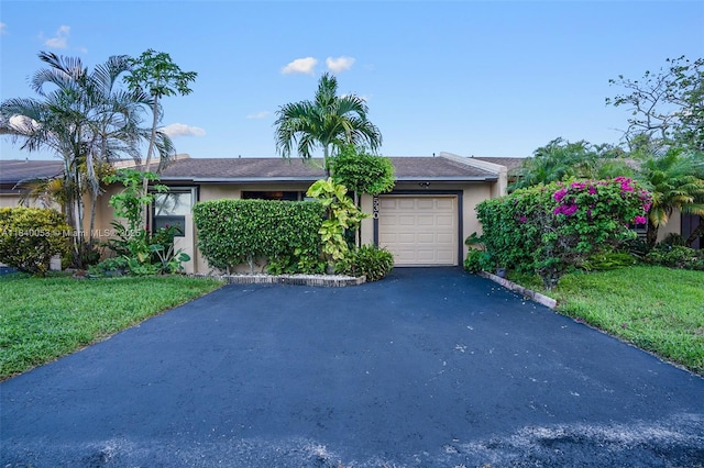 9530 W Daffodil Ln, Miramar, FL 33025 - ranch-style home with driveway, a garage, stucco siding, and a front yard