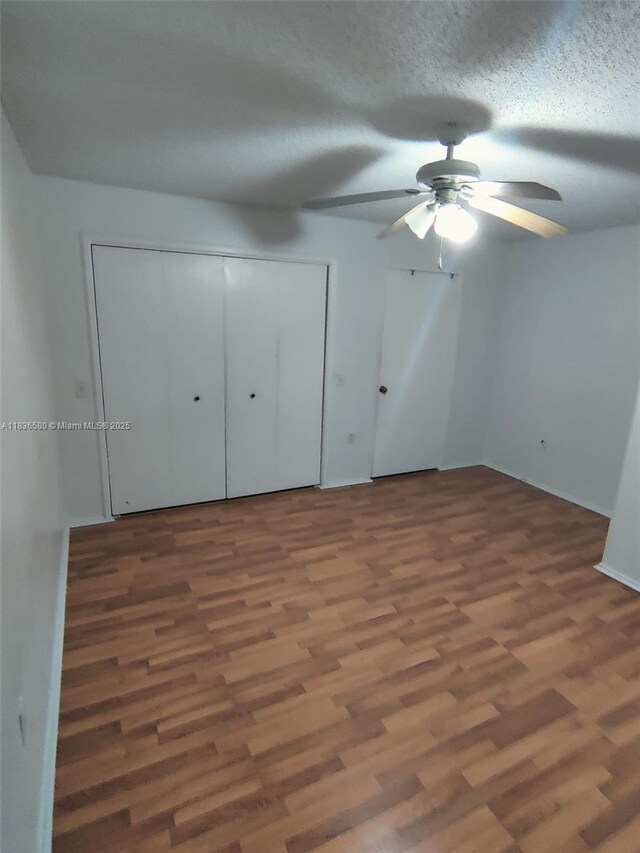 10361 SW 150th Ct Unit 13104, Miami, FL 33196 - unfurnished bedroom with wood finished floors, ceiling fan, a textured ceiling, and multiple closets