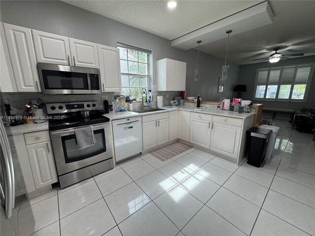 14972 SW 50th Ct, Davie, FL 33331 - kitchen featuring stainless steel appliances, backsplash, a peninsula, light countertops, and open floor plan