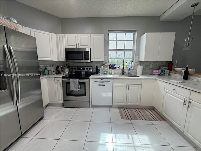 14972 SW 50th Ct, Davie, FL 33331 - kitchen featuring stainless steel appliances, tasteful backsplash, light countertops, and white cabinets