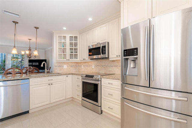200 NE 14th Ave Unit 524, Hallandale Beach, FL 33009 - kitchen featuring stainless steel appliances, light stone counters, glass insert cabinets, tasteful backsplash, and ornamental molding