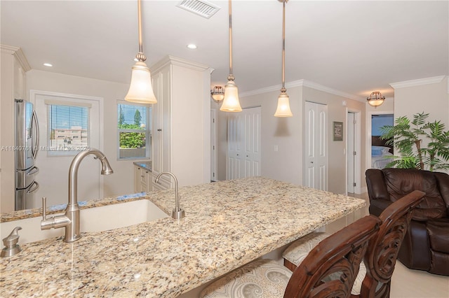 200 NE 14th Ave Unit 524, Hallandale Beach, FL 33009 - kitchen with stainless steel fridge, light stone countertops, a kitchen bar, white cabinetry, and crown molding