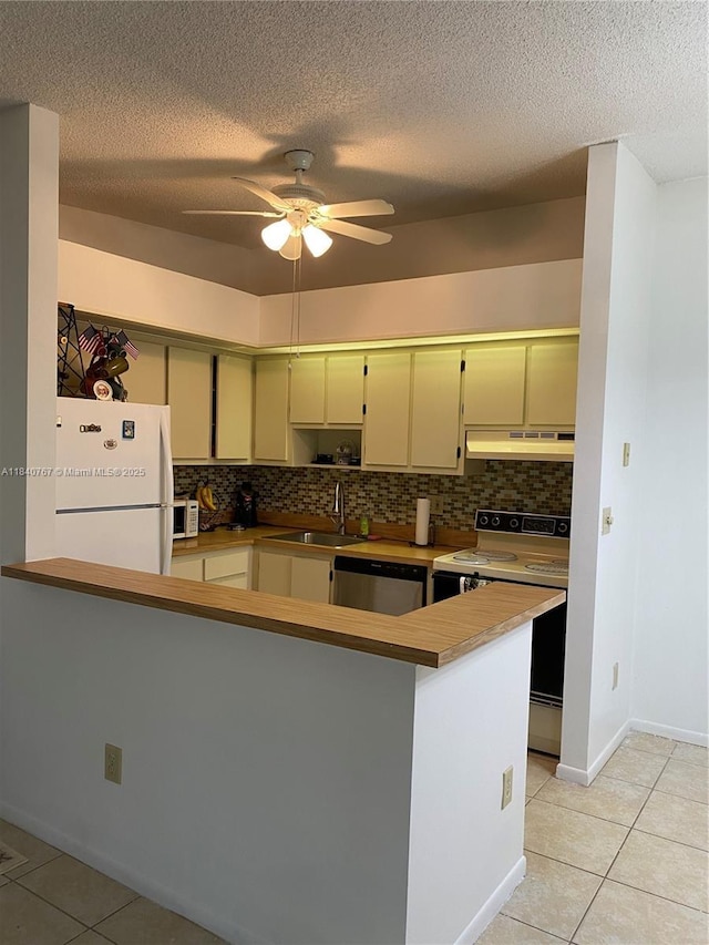 10407 E Clairmont Cir Unit 210, Tamarac, FL 33321 - kitchen with light tile patterned flooring, white appliances, backsplash, a ceiling fan, and under cabinet range hood