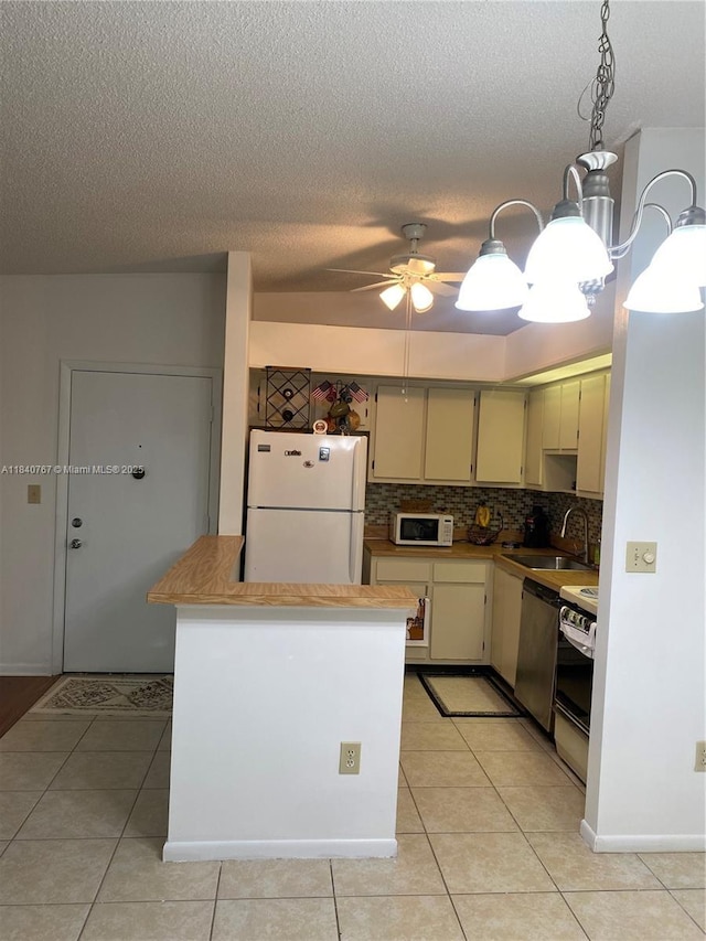 10407 E Clairmont Cir Unit 210, Tamarac, FL 33321 - kitchen featuring white appliances, light tile patterned floors, backsplash, cream cabinets, and ceiling fan
