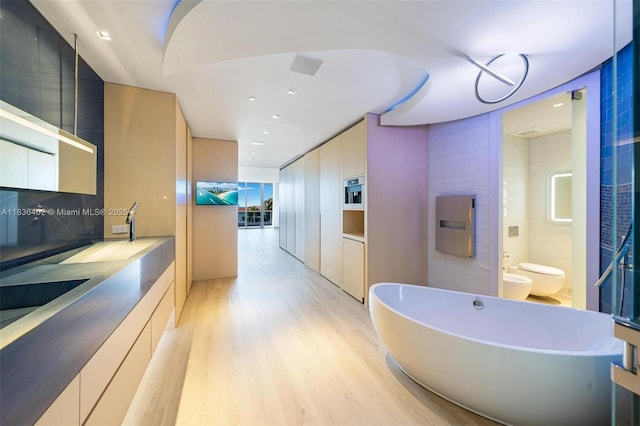 5959 Collins Ave Unit 705, Miami Beach, FL 33140 - full bath featuring wood finished floors, a bidet, a soaking tub, backsplash, and recessed lighting