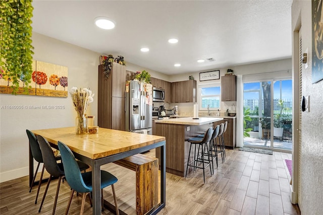 8657 SW 22nd Ct, Miramar, FL 33025 - kitchen with light wood-type flooring, light countertops, a kitchen breakfast bar, recessed lighting, and a kitchen island