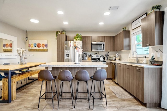 8657 SW 22nd Ct, Miramar, FL 33025 - kitchen with a kitchen bar, stainless steel appliances, a center island, light countertops, and recessed lighting