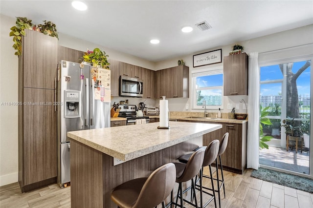 8657 SW 22nd Ct, Miramar, FL 33025 - kitchen featuring appliances with stainless steel finishes, a breakfast bar, light countertops, a kitchen island, and recessed lighting