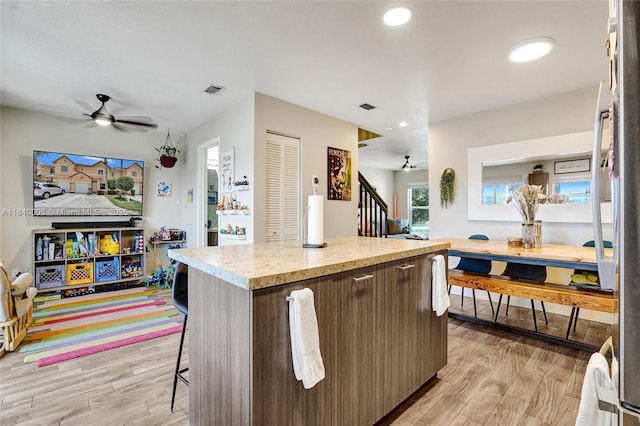 8657 SW 22nd Ct, Miramar, FL 33025 - kitchen featuring a ceiling fan, light countertops, light wood-type flooring, a center island, and open floor plan