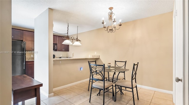 135 Heritage Way, West Palm Beach, FL 33407 - dining space featuring light tile patterned floors, a textured ceiling, and a chandelier