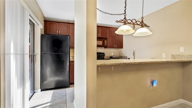 135 Heritage Way, West Palm Beach, FL 33407 - kitchen featuring black appliances, light tile patterned floors, light stone countertops, decorative light fixtures, and a kitchen bar