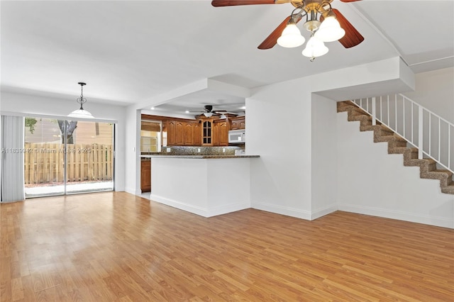 8713 SW 137th Ave Unit 8713, Miami, FL 33183 - unfurnished living room featuring ceiling fan, light wood-type flooring, and stairs