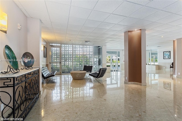 2100 W Sans Souci Blvd Unit E1, North Miami, FL 33181 - living area featuring tile patterned flooring, a paneled ceiling, and a wall of windows