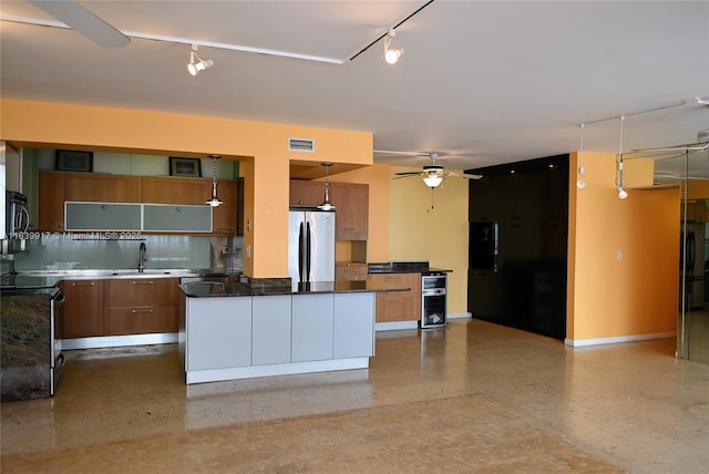 2100 W Sans Souci Blvd Unit E1, North Miami, FL 33181 - kitchen with track lighting, ceiling fan, appliances with stainless steel finishes, brown cabinets, and a kitchen island