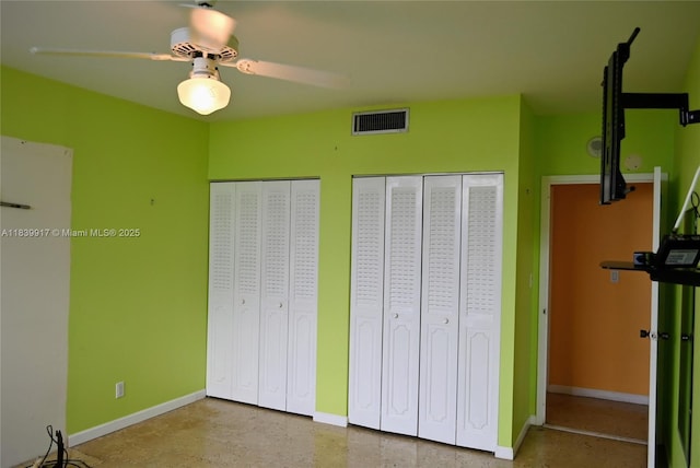 2100 W Sans Souci Blvd Unit E1, North Miami, FL 33181 - unfurnished bedroom featuring multiple closets and ceiling fan