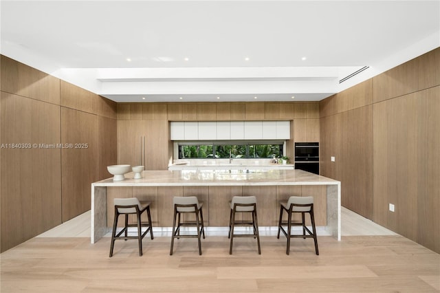 967 NE 117th St, Biscayne Park, FL 33161 - kitchen featuring modern cabinets, a kitchen breakfast bar, and a spacious island