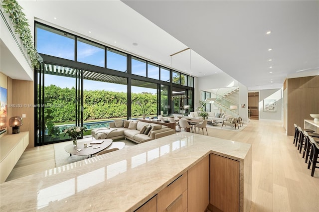 967 NE 117th St, Biscayne Park, FL 33161 - sunken living room with light wood finished floors, recessed lighting, and a wall of windows