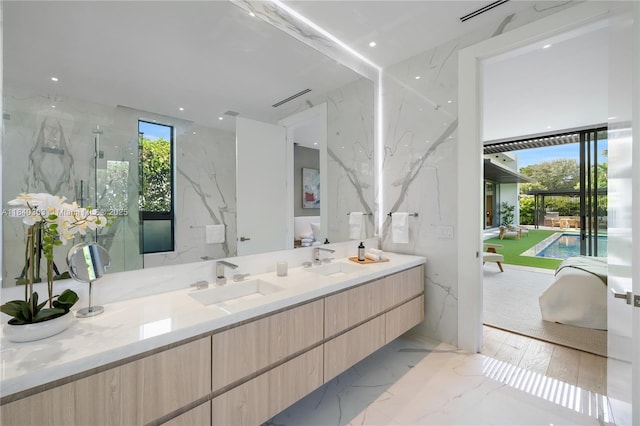 967 NE 117th St, Biscayne Park, FL 33161 - bathroom with double vanity, a marble finish shower, healthy amount of natural light, and stone wall