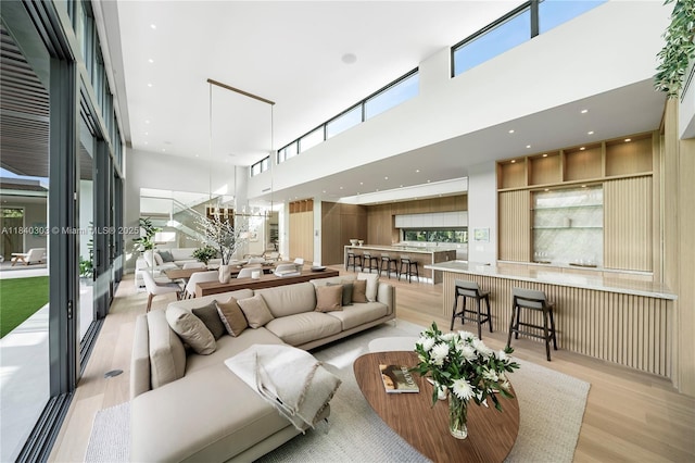 967 NE 117th St, Biscayne Park, FL 33161 - living room with light wood-type flooring, a towering ceiling, and healthy amount of natural light