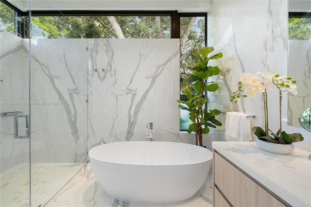 967 NE 117th St, Biscayne Park, FL 33161 - bathroom featuring vanity, a freestanding bath, tile walls, a marble finish shower, and marble tiled flooring