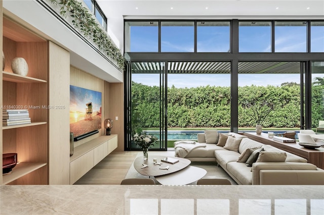 967 NE 117th St, Biscayne Park, FL 33161 - living room featuring light wood-style flooring, plenty of natural light, and a towering ceiling