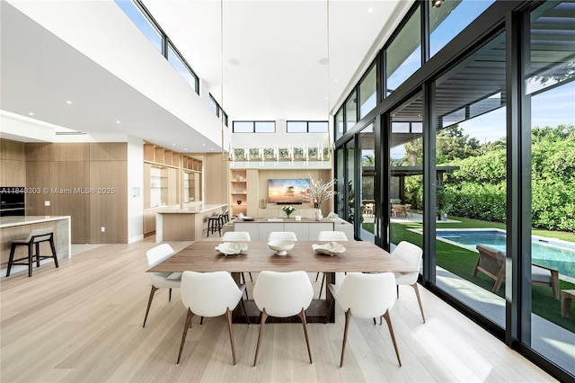 967 NE 117th St, Biscayne Park, FL 33161 - dining space featuring a high ceiling, healthy amount of natural light, and light wood finished floors