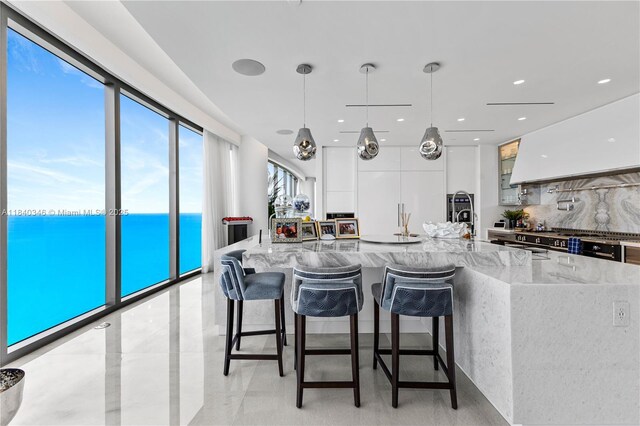 17901 Collins Ave Unit Ts4205, Sunny Isles Beach, FL 33160 - kitchen with light stone countertops, backsplash, modern cabinets, white cabinetry, and a water view