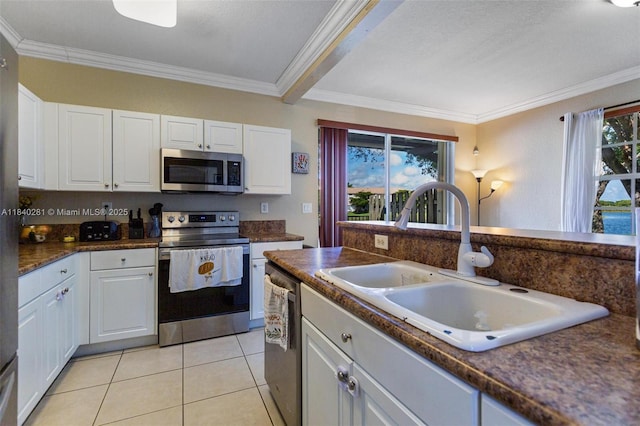 9333 SW 227th St Unit 8-6, Cutler Bay, FL 33190 - kitchen featuring stainless steel appliances, crown molding, dark countertops, white cabinets, and light tile patterned flooring
